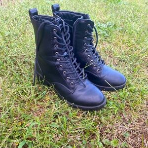 Black combat boots with laces.